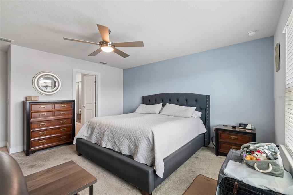 6608 Ryestone Way Wesley Chapel, FL 33545 - Photo 41 of 66 a bedroom with a bed and a chandelier