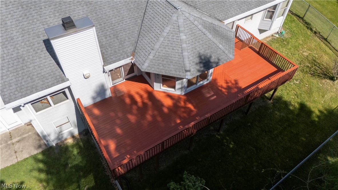 8745 Broadview Road Broadview Heights, OH 44147 - Photo 31 of 49 Expansive red-stained wood deck featuring a hexagonal sunroom extension, dark grey asphalt shingle roof, and a visible chimney structure