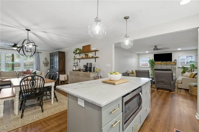 a view of a dining room and livingroom with furniture wooden floor a chandelier