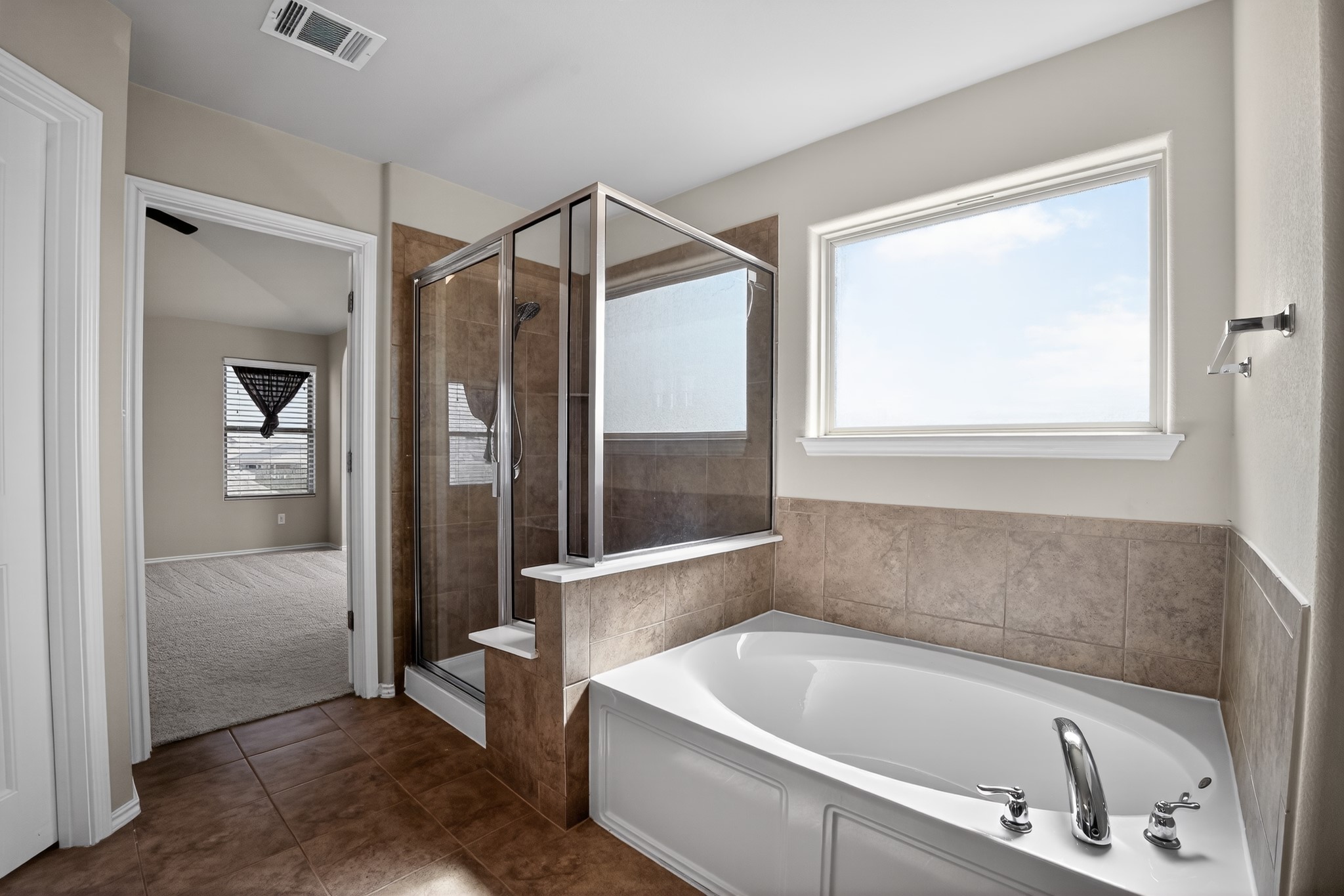 16816 Ruggio Road Pflugerville, TX 78660 - Photo 17 of 30 Indulge in a primary bathroom featuring a spacious soaking tub and a separate glass-enclosed shower.