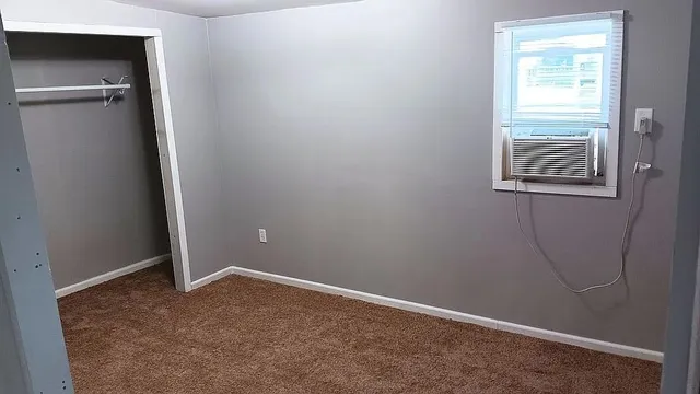 an empty room with windows and closet