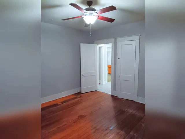 a view of empty room with wooden floor