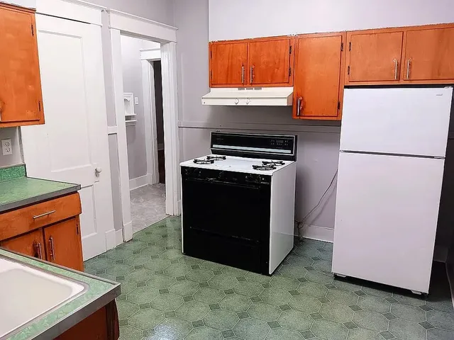 a kitchen with stainless steel appliances granite countertop a refrigerator a stove a sink and a refrigerator