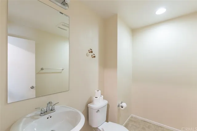 a bathroom with a toilet a sink and mirror