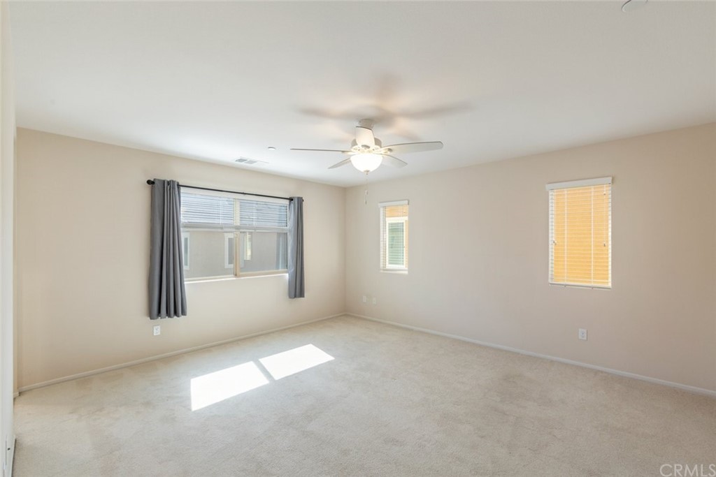 34159 Renton Drive Lake Elsinore, CA 92532 - Photo 17 of 35 an empty room with windows and chandelier fan