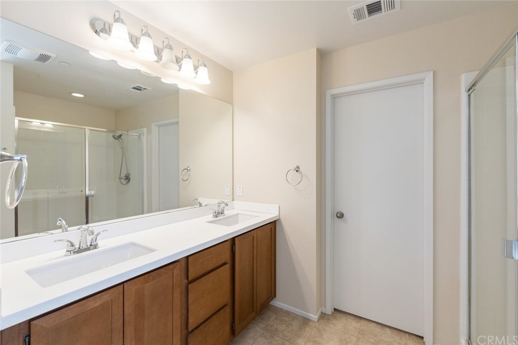 34159 Renton Drive Lake Elsinore, CA 92532 - Photo 18 of 35 a bathroom with a double vanity sink and a mirror