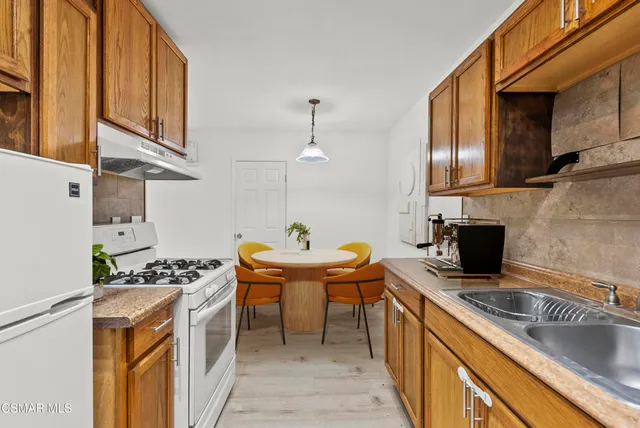 a kitchen with stainless steel appliances granite countertop a sink stove and wooden cabinets
