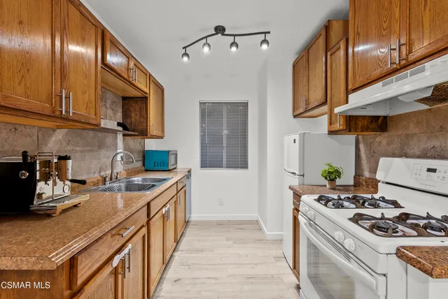a kitchen with stainless steel appliances granite countertop a stove and a sink