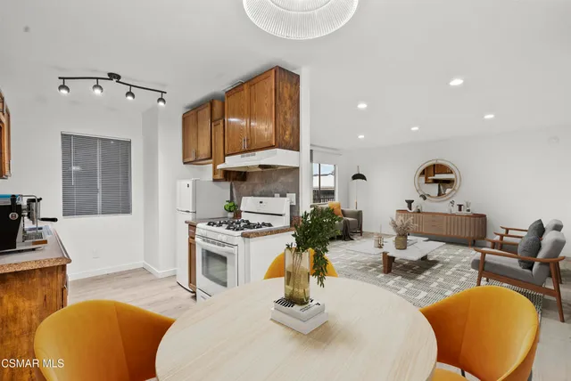 a living room with furniture a flat screen tv and kitchen view