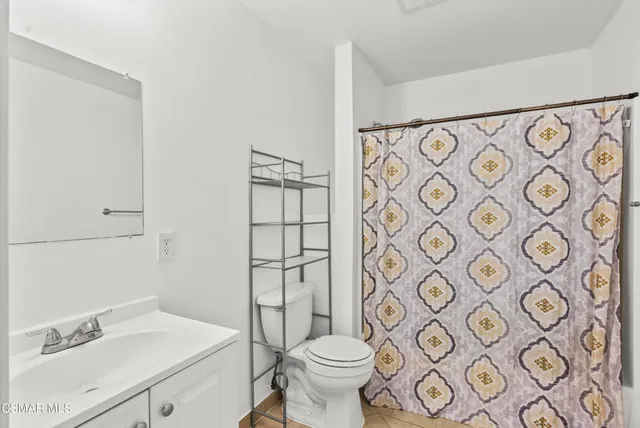 a bathroom with a toilet sink shower and mirror