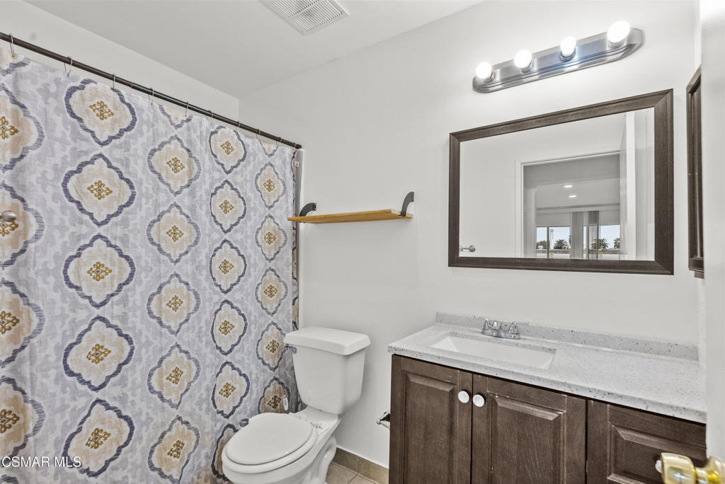 8800 Cedros Avenue, Unit 204 Panorama City, CA 91402 - Photo 8 of 11 a bathroom with a granite countertop toilet and a mirror