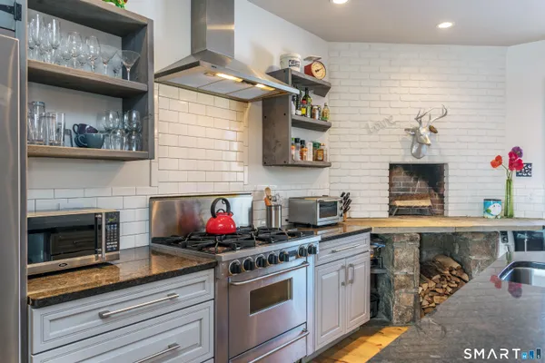 a kitchen with stainless steel appliances granite countertop a stove and cabinets