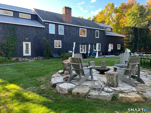 a front view of a house with garden and trees