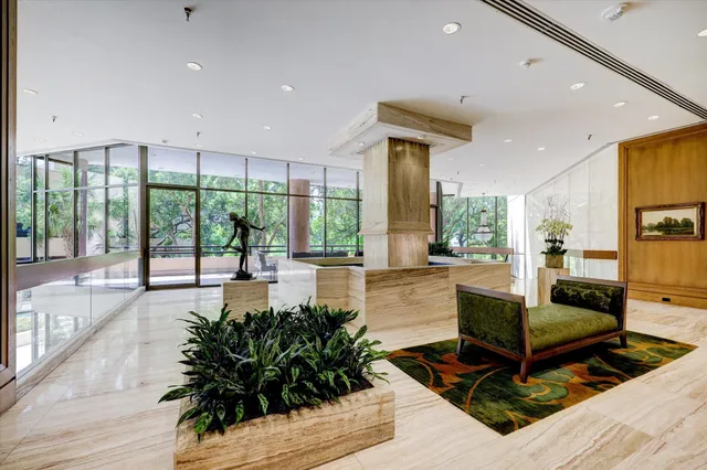 a living room with furniture large windows and wooden floor