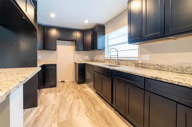 a kitchen with stainless steel appliances granite countertop a sink stove and refrigerator