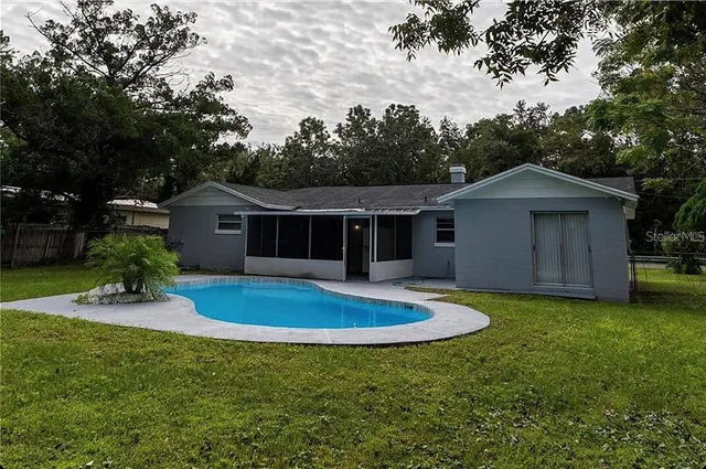 a front view of house with garden and trees