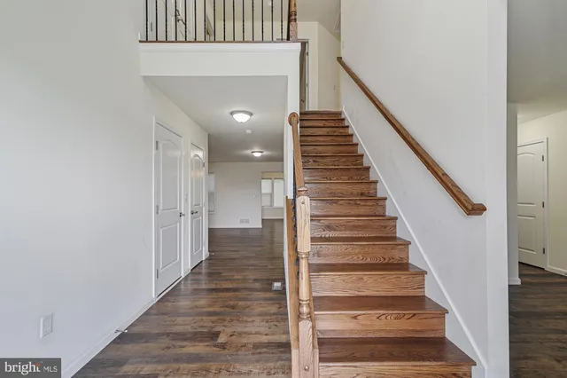 a view of staircase with wooden floor and white walls