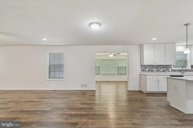 a view of a kitchen with a sink and dishwasher with wooden floor