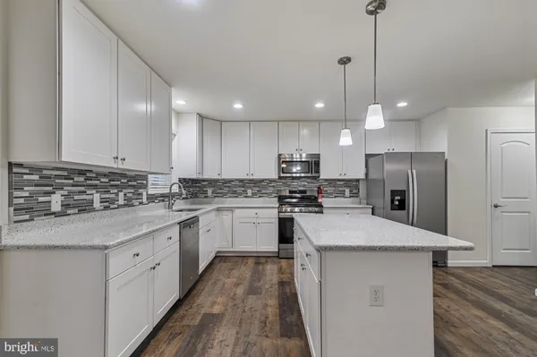 a kitchen with a refrigerator a sink and cabinets
