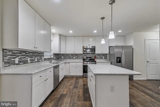 a kitchen with a refrigerator a sink and cabinets