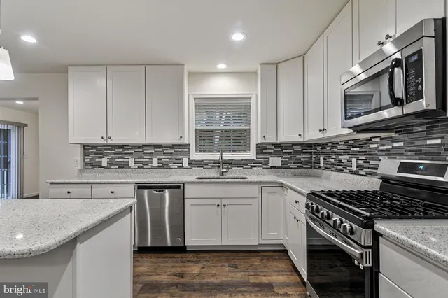 a kitchen with stainless steel appliances granite countertop a stove and a sink
