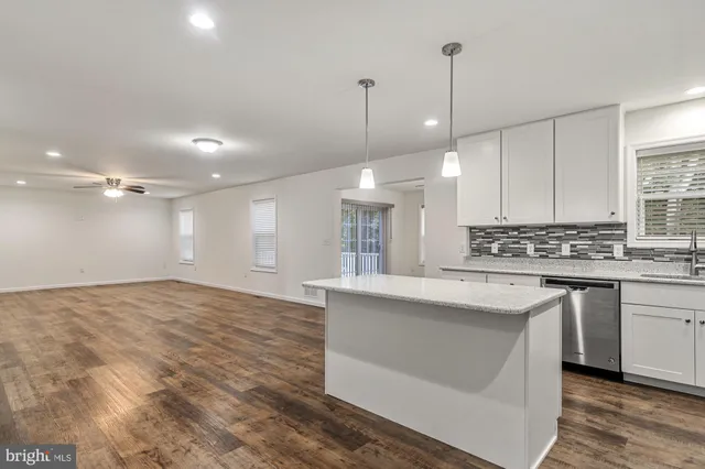 a large kitchen with kitchen island a sink stainless steel appliances and cabinets