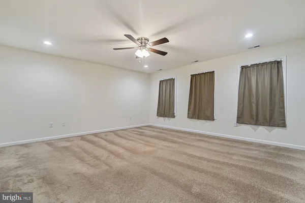 a view of an empty room with a ceiling fan