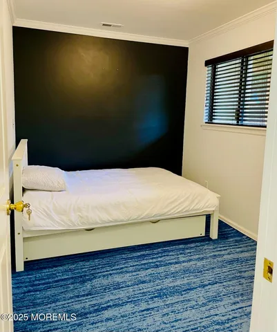 a bed sitting in a bedroom next to a window