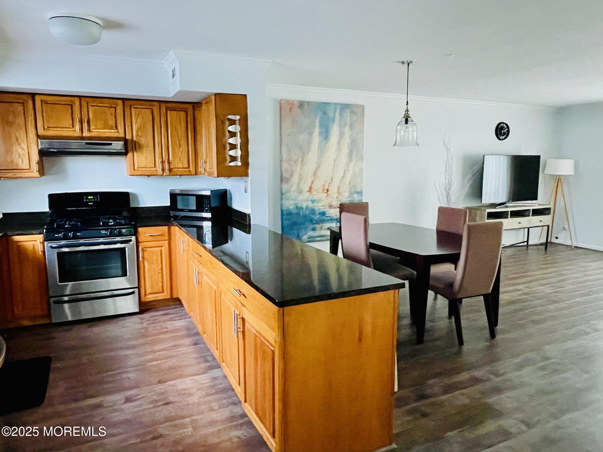 190 Spruce Street, Unit 8 Long Branch, NJ 07740 - Photo 5 of 15 a kitchen with stainless steel appliances granite countertop a stove top oven a sink a dining table and chairs with wooden floor