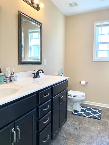 a bathroom with a toilet sink and mirror