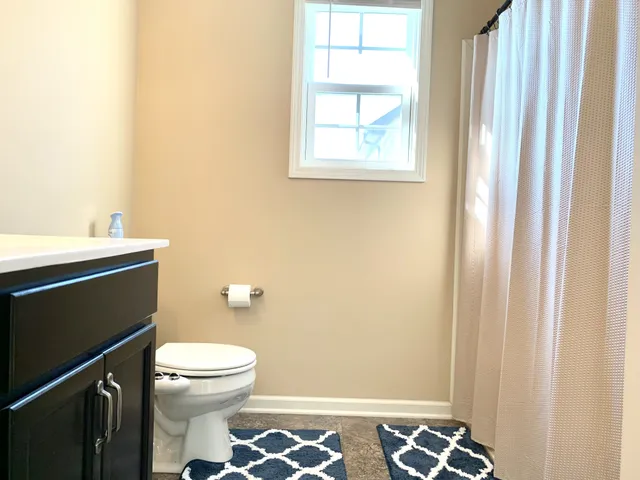 a bathroom with a toilet a sink and a window