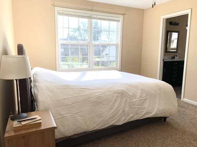 a bed sitting in a bedroom next to a window