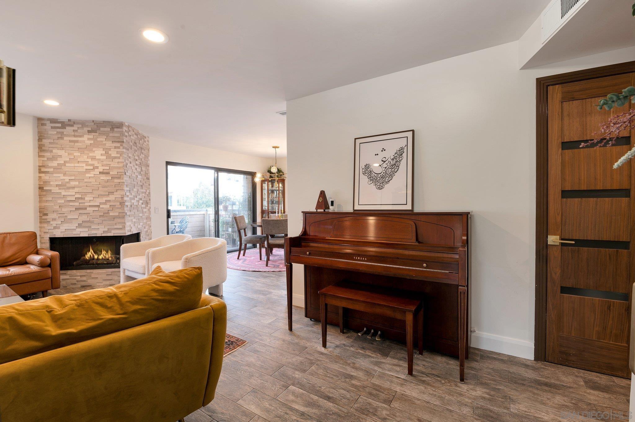 a living room with furniture a piano and a fireplace