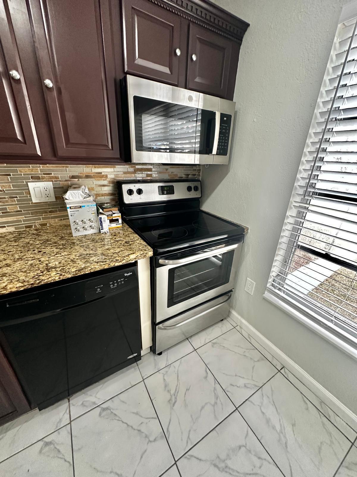 4158 Inverrary Drive, Unit 202 Lauderhill, FL 33319 - Photo 5 of 20 a kitchen with granite countertop a stove and a microwave