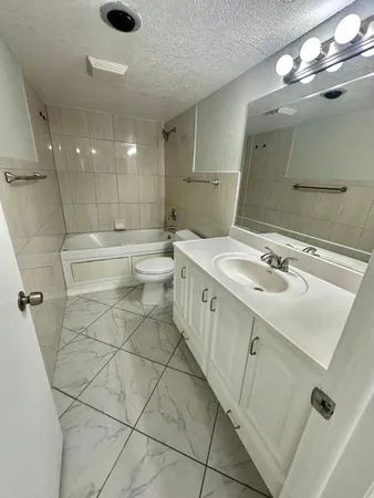 a bathroom with a sink a toilet a mirror and shower