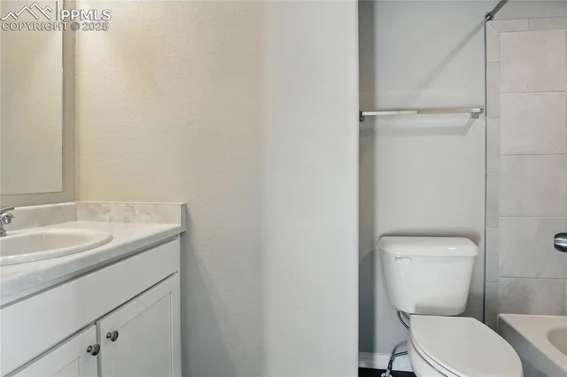 a bathroom with a toilet sink vanity and mirror