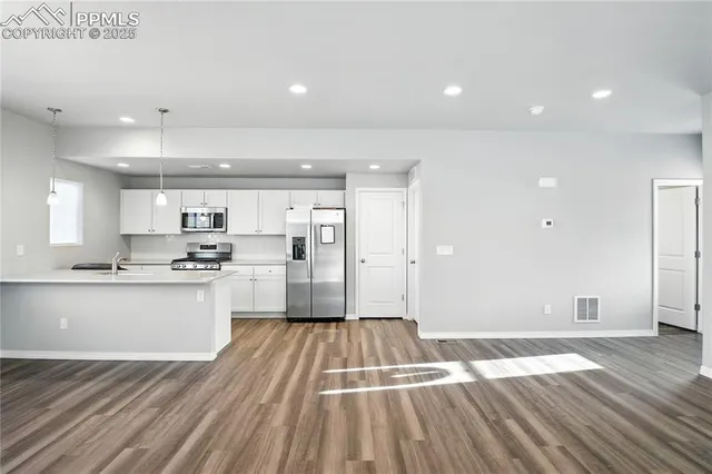 a large kitchen with granite countertop a large counter top and stainless steel appliances