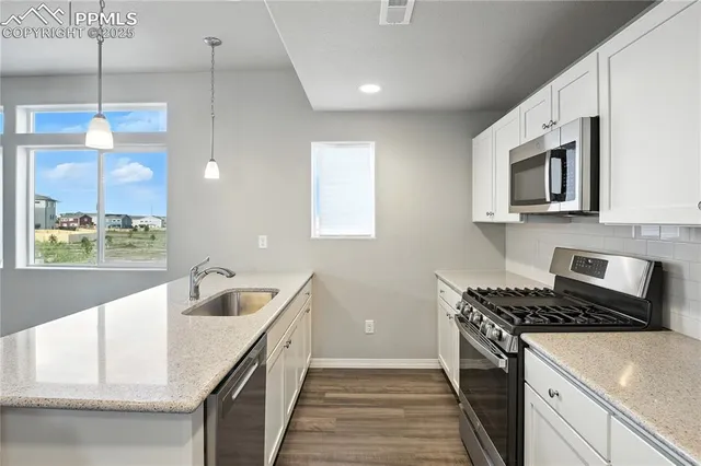 a kitchen that has a sink and a stove in it