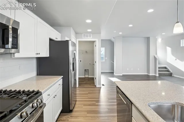 a kitchen with stainless steel appliances granite countertop a sink and a stove