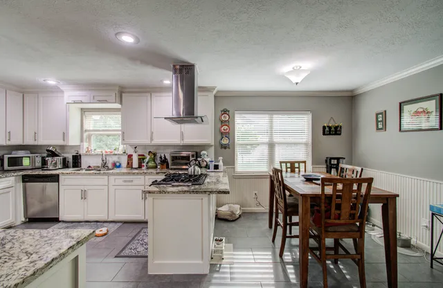 a kitchen with a table chairs stove and cabinets