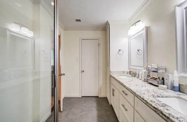 a large bathroom with a granite countertop double vanity sink and a mirror