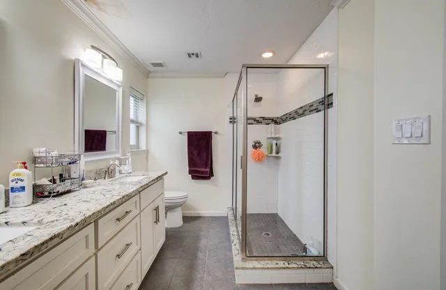 a spacious bathroom with a double vanity sink a mirror and a shower