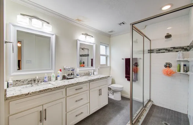 a bathroom with a granite countertop sink toilet and shower