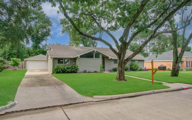 a front view of a house with a yard and trees