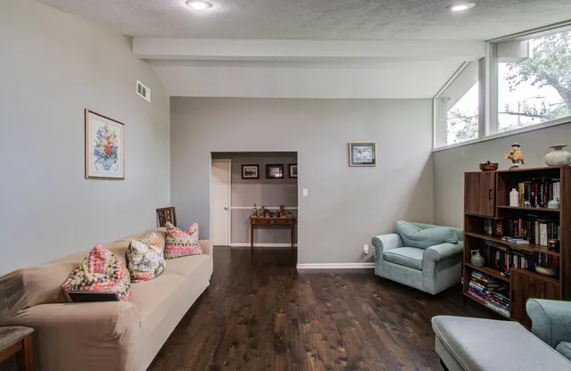 a living room with furniture and a book shelf