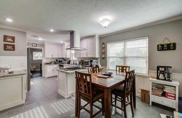 a kitchen with kitchen island a dining table and chairs