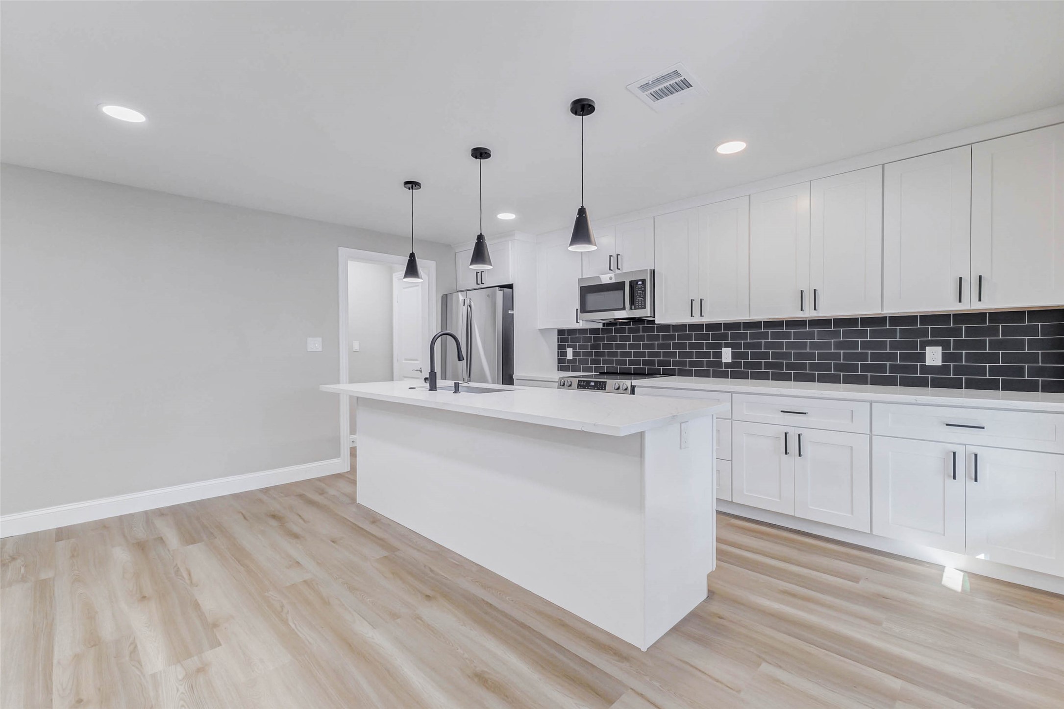 1054 Dewalt Street Houston, TX 77088 - Photo 15 of 24 a kitchen with stainless steel appliances white cabinets and wooden floor