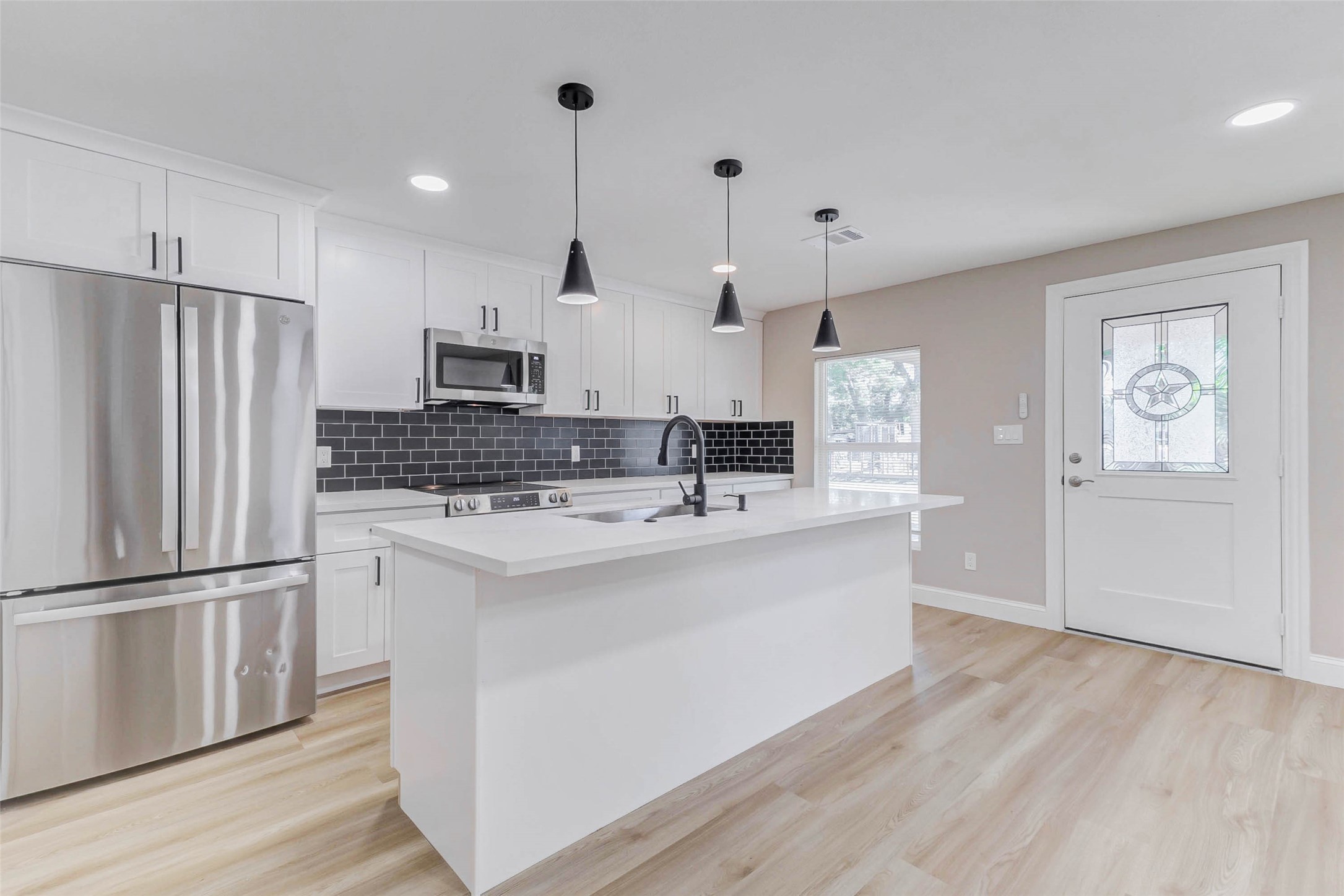 1054 Dewalt Street Houston, TX 77088 - Photo 16 of 24 a kitchen with stainless steel appliances granite countertop a refrigerator a oven a sink and white cabinets with wooden floor