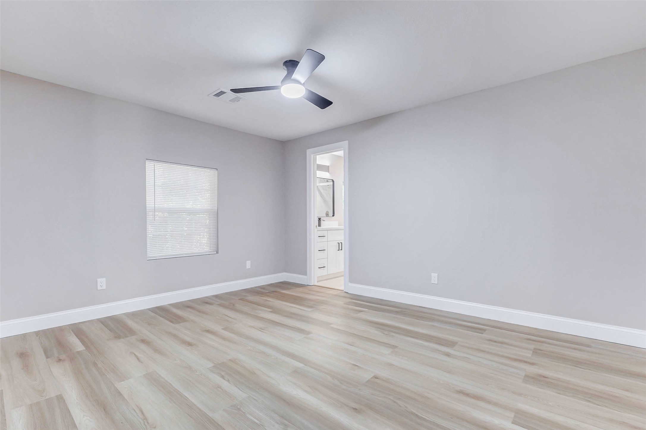 1054 Dewalt Street Houston, TX 77088 - Photo 21 of 24 an empty room with wooden floor and windows