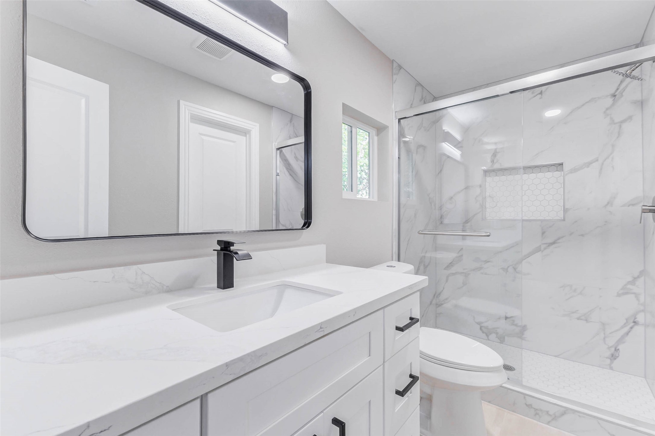 1054 Dewalt Street Houston, TX 77088 - Photo 23 of 24 a bathroom with a sink a toilet and a mirror